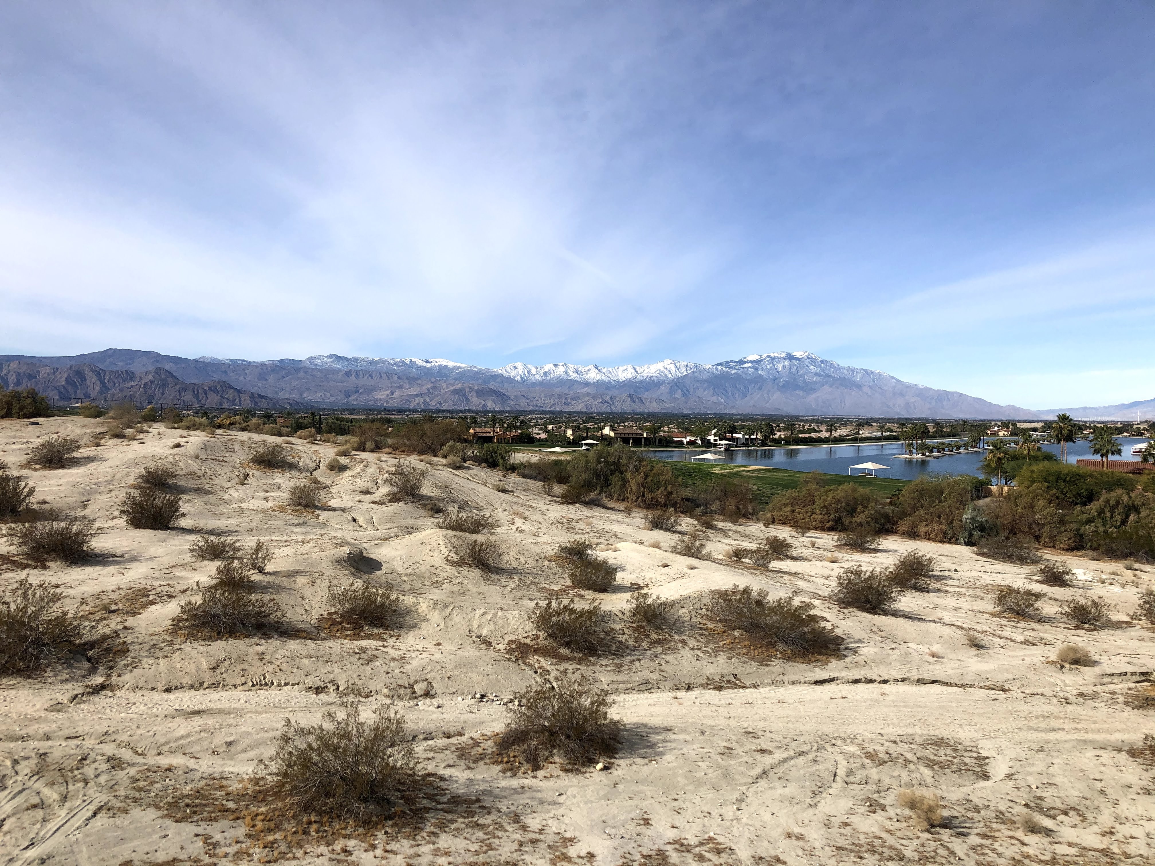 Shows a manmade lake with snowy mountains in the background